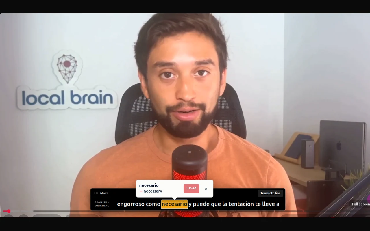 PinSpanish on YouTube: the Spanish word necesario is selected with its English meaning necessary and a Saved confirmation above the subtitle.